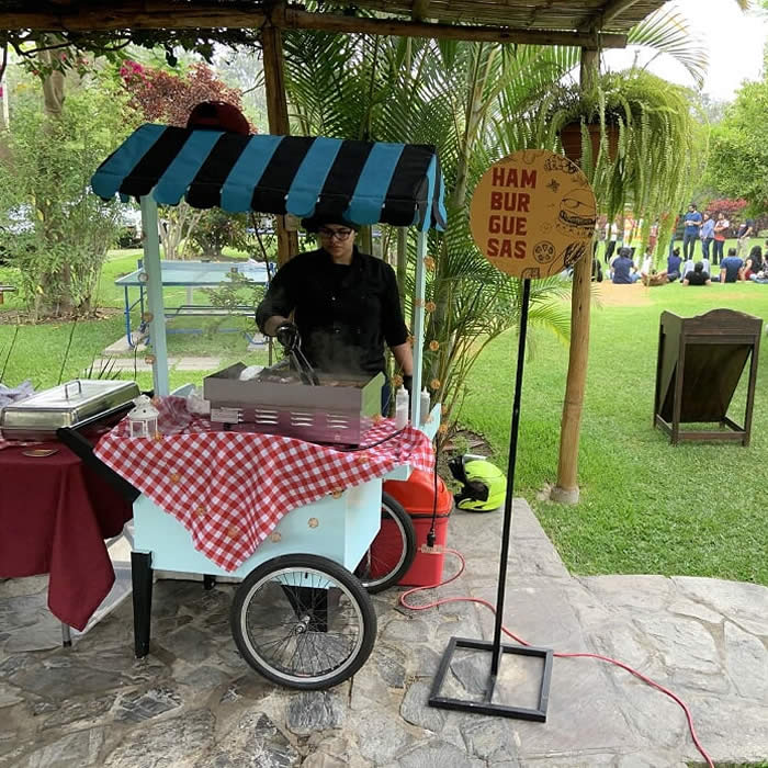 carrito snack de sanguchazo preparando hamburguesas en evento corporativo de inlearning